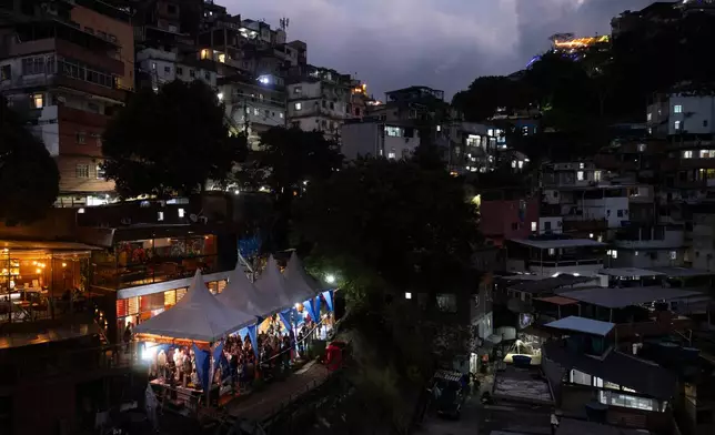 People attend a performance by American vocalist of Hindu devotional music Jeff Kagel during a Tranformation Project yoga class in the Rocinha favela, Rio de Janeiro, Wednesday, July 9, 2025. (AP Photo/Bruna Prado)