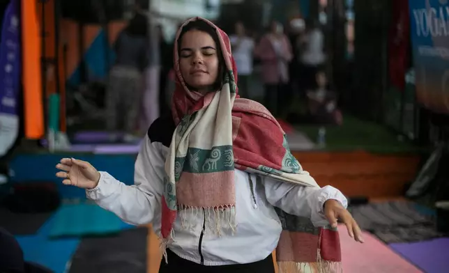 A woman dances during a performance by American vocalist of Hindu devotional music Jeff Kagel during a Transformation Project yoga class in the Rocinha favela in Rio de Janeiro, Wednesday, July 9, 2025. (AP Photo/Bruna Prado)
