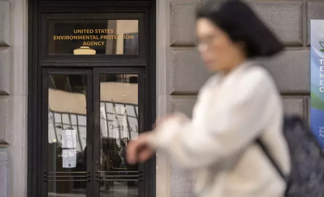 FILE - A person walks past the headquarters building of the Environmental Protection Agency, March 12, 2025, in Washington. (AP Photo/Mark Schiefelbein, File)