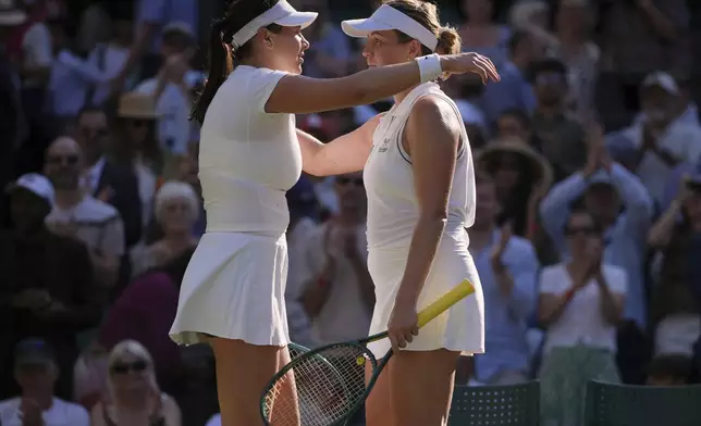 Anastasia Pavlyuchenkova of Russia, right, and Amanda Anisimova of the U.S. hug after the women's singles quarter finals match at the Wimbledon Tennis Championships in London, Tuesday, July 8, 2025.(AP Photo/Kin Cheung)