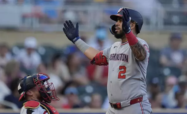 Washington Nationals' Luis García Jr. (2) celebrates next to Minnesota Twins catcher Christian Vázquez, left, while crossing home plate after hitting a solo home run during the fourth inning of a baseball game Saturday, July 26, 2025, in Minneapolis. (AP Photo/Abbie Parr)