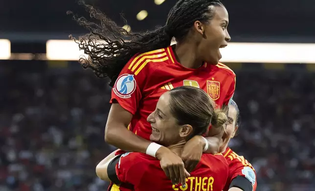 Spain's Esther Gonzalez celebrates scoring with teammate Vicky Lopez, top, during the Euro 2025, group B, soccer match between Spain and Portugal at Stadion Wankdorf in Bern, Switzerland, Thursday, July 3, 2025. (Peter Klaunzer/Keystone via AP)