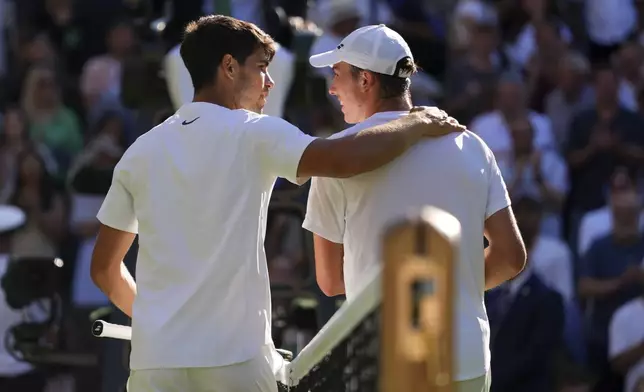 Carlos Alcaraz of Spain and Oliver Tarvet of Britain, right, chat after their second round men's singles match at the Wimbledon Tennis Championships in London, Wednesday, July 2, 2025.(AP Photo/Kirsty Wigglesworth)