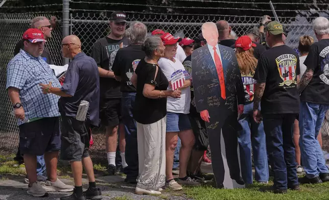 Attendees wait in line for an event with Vice President JD Vance with a cutout of President Donald Trump at Don's Machine Shop in West Pittston, Pa., Wednesday, July 16, 2025. (AP Photo/Matt Rourke)