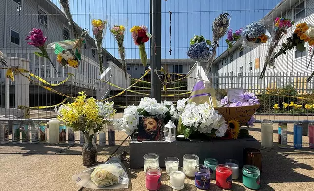 Flowers sit at a makeshift memorial in front of the Gabriel House assisted living facility, where a fire on Sunday killed several people, Wednesday, July 16, 2025 in Fall River, Mass. (AP Photo/Rodrique Ngowi)