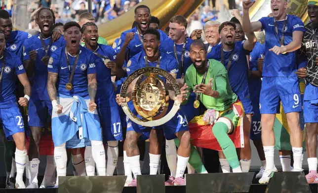 President Donald Trump, back from fourth from right, stands on stage after presenting the championship trophy to Chelsea following the Club World Cup final soccer match between Chelsea and PSG at MetLife Stadium in East Rutherford, N.J., Sunday, July 13, 2025. (AP Photo/Jacquelyn Martin)