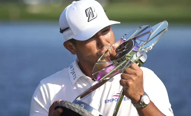 Kurt Kitayama, left, is presented with a trophy after winning the 3M Open golf tournament at the Tournament Players Club Sunday, July 27, 2025, in Blaine, Minn. (AP Photo/Abbie Parr)
