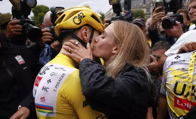 Slovenia's Tadej Pogacar, the Tour de France winner, is greeted by his partner Urska Zigart after finishing, the twenty-first stage of the Tour de France cycling race over 132.3 kilometers (82.1 miles) with start in Mantes-la-Ville and finish on the Champs-Elysees in Paris, France, Sunday, July 27, 2025. (Yoan Valat, Pool Photo via AP)
