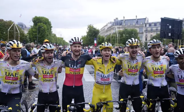 Tour de France winner Tadej Pogacar of Slovenia and teammates from left, Germany's Nils Politt, Britain's Adam Yates, Belgium's Tim Wellens, France's Pavel Sivakov, Belgium's Tim Wellens and Ecuador's Jhonatan Narvaez, celebrate after the twenty-first stage of the Tour de France cycling race over 132.3 kilometers (82.1 miles) with start in Mantes-la-Ville and finish on the Champs-Elysees in Paris, France, Sunday, July 27, 2025. (AP Photo/Mosa'ab Elshamy)