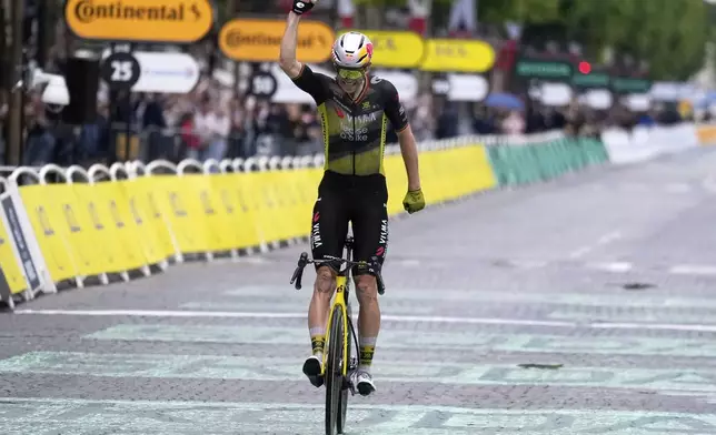 Belgium's Wout van Aert crosses the finish line to win the twenty-first stage of the Tour de France cycling race over 132.3 kilometers (82.1 miles) with start in Mantes-la-Ville and finish on the Champs-Elysees in Paris, France, Sunday, July 27, 2025. (AP Photo/Mosa'ab Elshamy)