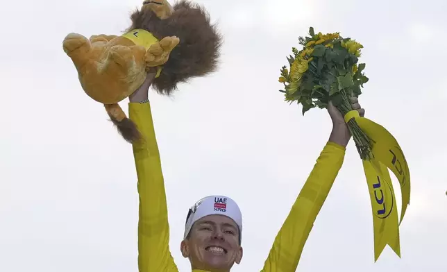 Tour de France winner Tadej Pogacar of Slovenia celebrates on the podium after the twenty-first stage of the Tour de France cycling race over 132.3 kilometers (82.1 miles) with start in Mantes-la-Ville and finish on the Champs-Elysees in Paris, France, Sunday, July 27, 2025. (AP Photo/Mosa'ab Elshamy)