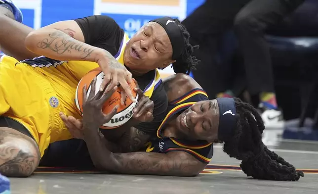 Los Angeles Sparks' Emma Cannon (32) and Indiana Fever's Natasha Howard (6) batlle for a loose ball during the second half of a WNBA basketball game, Saturday, July 5, 2025, in Indianapolis. (AP Photo/Michael Conroy)