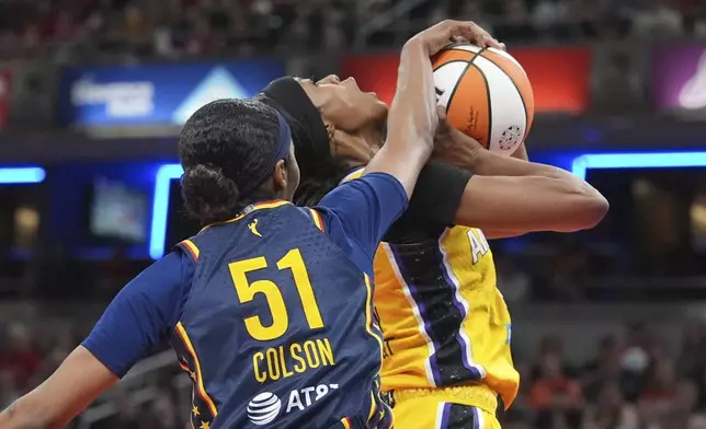 Indiana Fever's Sydney Colson (51)blocks the shot of Los Angeles Sparks' Rickea Jackson during the second half of a WNBA basketball game, Saturday, July 5, 2025, in Indianapolis. (AP Photo/Michael Conroy)