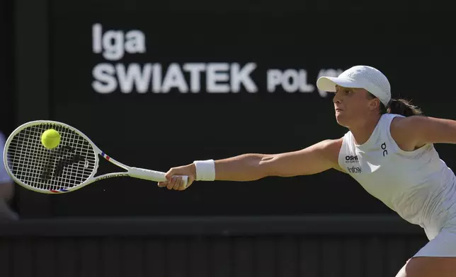 Poland's Iga Swiatek returns to Switzerland's Belinda Bencic during a women's singles semifinal match at the Wimbledon Tennis Championships in London, Thursday, July 10, 2025. (AP Photo/Kin Cheung)