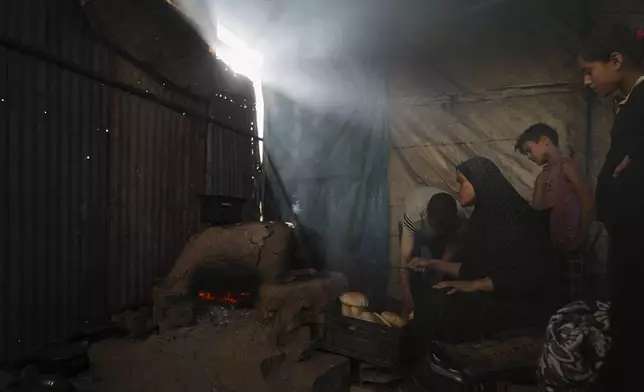 Displaced Palestinians bake bread in a school now serving as a shelter in Deir al-Balah, Gaza Strip Sunday, July 6, 2025. (AP Photo/Abdel Kareem Hana)