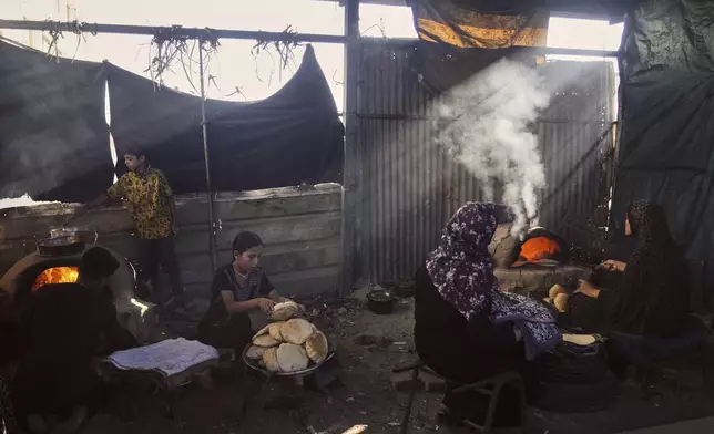 Displaced Palestinians bake bread in a school now serving as a shelter in Deir al-Balah, Gaza Strip Sunday, July 6, 2025. (AP Photo/Abdel Kareem Hana)
