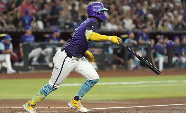 Arizona Diamondbacks' Geraldo Perdomo watches the flight of his two-run single against the St. Louis Cardinals during the second inning of a baseball game Friday, July 18, 2025, in Phoenix. (AP Photo/Ross D. Franklin)