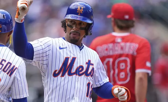 New York Mets' Francisco Lindor (12) gestures to teammates after hitting an RBI single during the fourth inning of a baseball game against the Los Angeles Angels Wednesday, July 23, 2025, in New York. (AP Photo/Frank Franklin II)