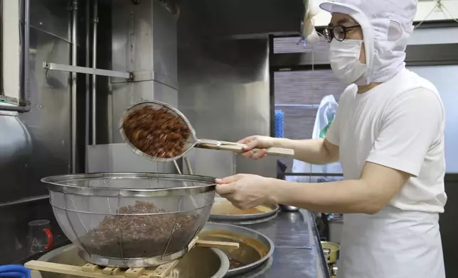 Yoshihiro Kobayashi prepares tsukudani, a Japanese preserved food, in Tsukuda, Tokyo on June 18, 2025. (AP Photo/Yuri Kageyama)