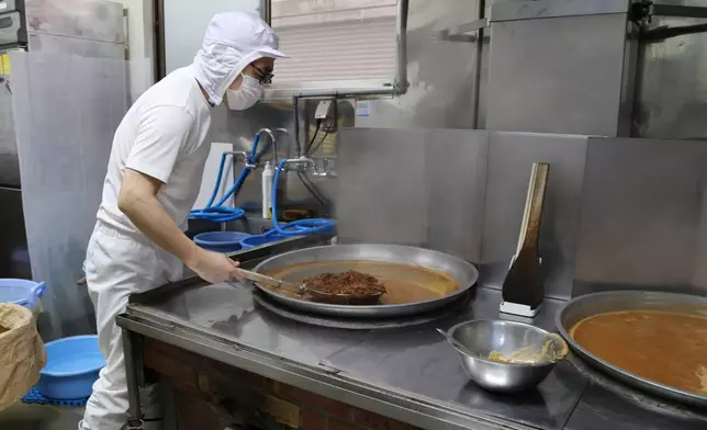 Yoshihiro Kobayashi prepares tsukudani, a Japanese preserved food, in Tsukuda, Tokyo on June 18, 2025. (AP Photo/Yuri Kageyama)