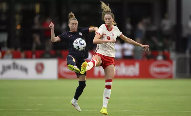 United States defender Emily Sonnett, left, and Canada forward Jordyn Huitema (9) battle for the ball during the first half of an international friendly soccer match, Wednesday, July 2, 2025, in Washington. (AP Photo/Nick Wass)