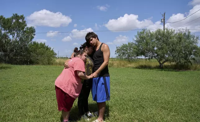 Juanita is hugged by her children, Jose, 15, and daughter Marely, 17, who has Down syndrome, Tuesday, June 17, 2025, during a portrait in Hidalgo County, Texas. (AP Photo/Jacquelyn Martin)