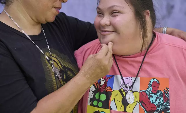 Juanita embraces her daughter Marely, 17, who has Down syndrome, Tuesday, June 17, 2025, during a portrait in a colonia, a type of informal neighborhood found in parts of rural Texas, in Hidalgo County, Texas. (AP Photo/Jacquelyn Martin)