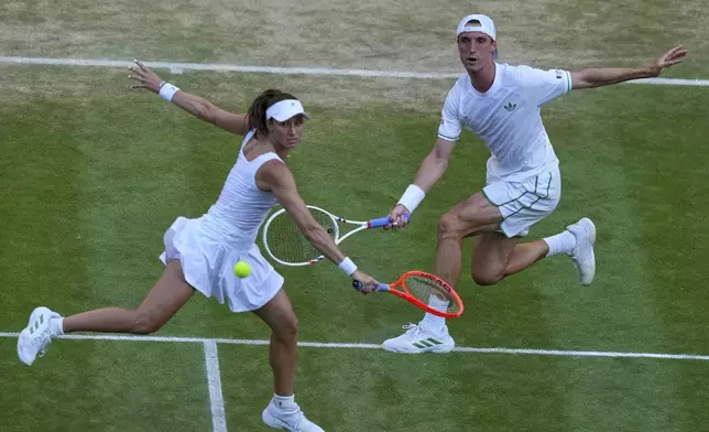 Joe Salisbury of Britain and Luisa Stefani of Brazil return the ball during the mixed doubles final match against Sem Verbeek of Netherland and Katerina Siniakova of Czech Republic at the Wimbledon Tennis Championships in London, Thursday, July 10, 2025. (AP Photo/Joanna Chan)