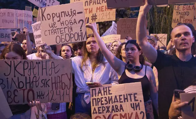 Participants hold banners during a protest against a law targeting anti-corruption institutions in central Kyiv, Ukraine, Wednesday, July 23, 2025. (AP Photo/Efrem Lukatsky)