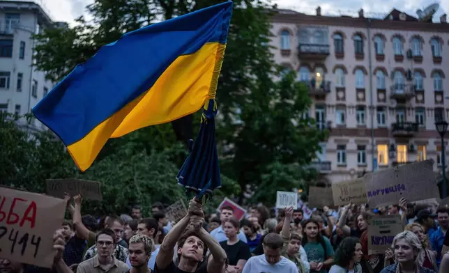 A man waves a flag during a protest against a law targeting anti-corruption institutions in central Kyiv, Ukraine, Tuesday, July 22, 2025. (AP Photo/Alex Babenko)