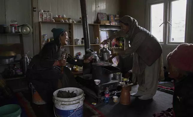 Kunzias Dolma, left, pours a cup of tea for her relative inside a plastic shelter provided by the government in Tsoltak village, Ladakh, India, Tuesday, July 8, 2025. (AP Photo/Dar Yasin)