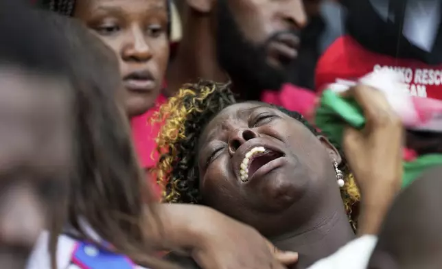 Susan Nyambura Njeri, the mother of vendor Boniface Kariuki, who was shot at close range by a police officer during last month's protests reacts in grief as they lower his casket into the grave in Kangema, Muranga County, Kenya, Friday, July 11, 2025. (AP Photo/Brian Inganga)