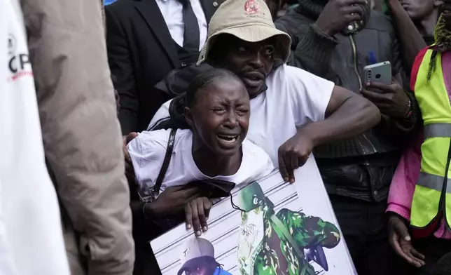 A mourner grieves as vendor Boniface Kariuki, who was shot at close range by a police officer during last month's protests, is laid to rest at her parents' farm in Kangema, Muranga County, Kenya, Friday, July 11, 2025. (AP Photo/Brian Inganga)