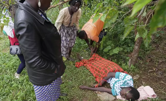 A mourner collapses as they lower the casket of vendor Boniface Kariuki, who was shot at close range by a police officer during last month's protests, in Kangema, Muranga County, Kenya, Friday, July 11, 2025. (AP Photo/Brian Inganga)