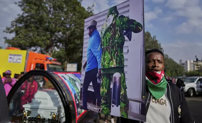 A mourner displays a photograph that shows a Kenyan police preparing to shoot vendor Boniface Kariuki at close range during last month's protests at the Kenyatta Memorial Funeral Home in Kiambu County, Kenya, Friday, July 11, 2025. (AP Photo/Brian Inganga)