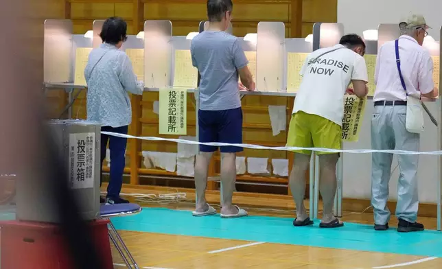Voters fill in their ballots in the upper house election at a polling station Sunday, July 20, 2025, in Tokyo. (AP Photo/Eugene Hoshiko)