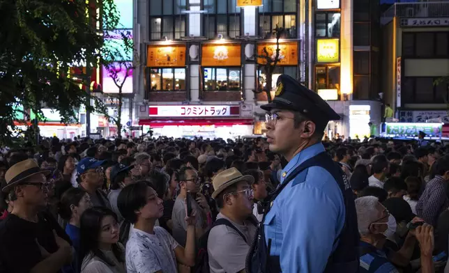 A police officer watches as supporters attend an election campaign event in support of Liberal Democratic Party candidates on the eve of the July 20 Upper House election in Tokyo, Saturday, July 19, 2025. (AP Photo/Louise Delmotte)