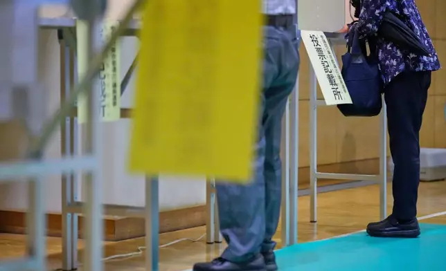 Voters fill in their ballots in the upper house election at a polling station Sunday, July 20, 2025, in Tokyo. (AP Photo/Eugene Hoshiko)
