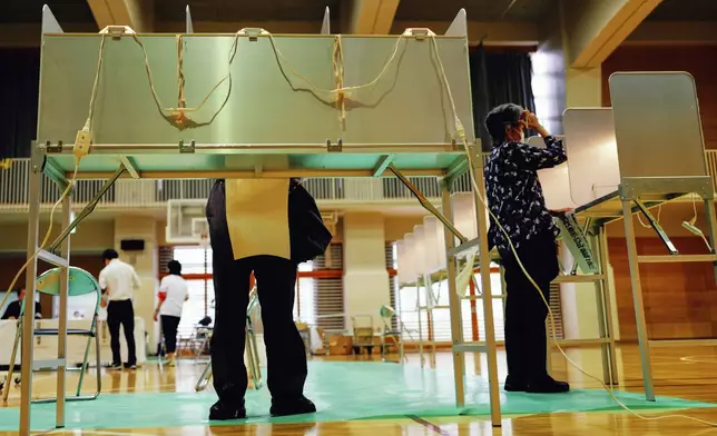 Voters fill in their ballots in the upper house election at a polling station Sunday, July 20, 2025, in Tokyo. (AP Photo/Eugene Hoshiko)