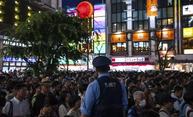 A police officer watches as supporters attend an election campaign event in support of Liberal Democratic Party candidates on the eve of the July 20 Upper House election, in Tokyo, Saturday, July 19, 2025. (AP Photo/Louise Delmotte)