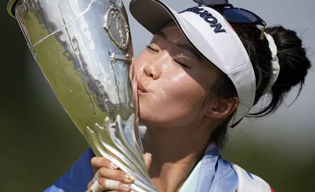Grace Kim, of Australia, kisses her trophy after winning the Evian Championship women's golf tournament, in Evian, eastern France, Sunday, July 13, 2025. (AP Photo/Laurent Cipriani)