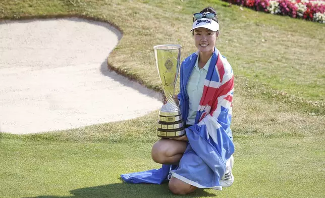 Grace Kim, of Australia, celebrates with her trophy after winning the Evian Championship women's golf tournament, in Evian, eastern France, Sunday, July 13, 2025. (AP Photo/Laurent Cipriani)