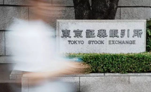 A person walks in front of Tokyo Stock Exchange building Friday, July 11, 2025, in Tokyo. (AP Photo/Eugene Hoshiko)