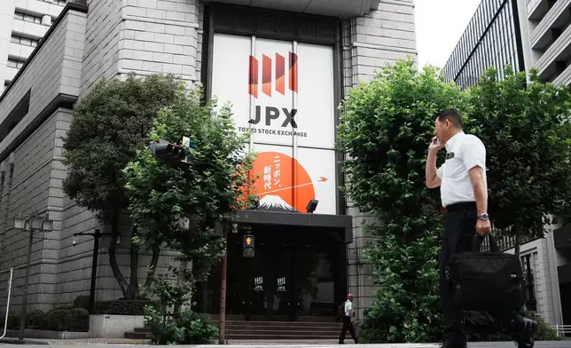 A person walks in front of Tokyo Stock Exchange building Friday, July 11, 2025, in Tokyo. (AP Photo/Eugene Hoshiko)
