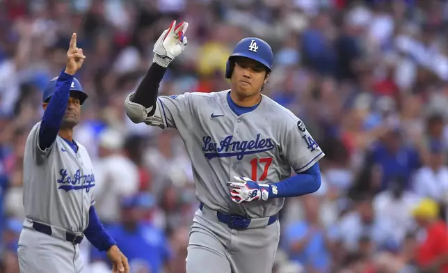 Los Angeles Dodgers' Shohei Ohtani (17) celebrates his home run in front of Dodgers third base coach Dino Ebel, left, in the first inning of a baseball game against the Boston Red Sox , Saturday, July 26, 2025, in Boston. (AP Photo/Steven Senne)