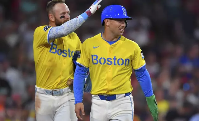 Boston Red Sox's Alex Bregman, right, celebrates with Trevor Story, left, after scoring on a double hit by Roman Anthony in the fifth inning of a baseball game against the Los Angeles Dodgers, Saturday, July 26, 2025, in Boston. (AP Photo/Steven Senne)