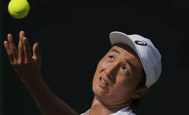 Shintaro Mochizuki of Japan serves the ball to Karen Khachanov of Russia in their second round men's singles match during the Wimbledon Tennis Championships in London, Wednesday, July 2, 2025.(AP Photo/Kin Cheung)