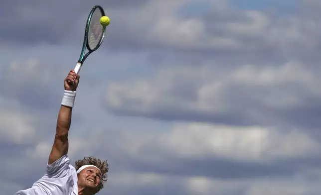 August Holmgren of Denmark serves to Tomas Machac of Czech Republic during their second round men's singles match at the Wimbledon Tennis Championships in London, Thursday, July 3, 2025.(AP Photo/Kirsty Wigglesworth)