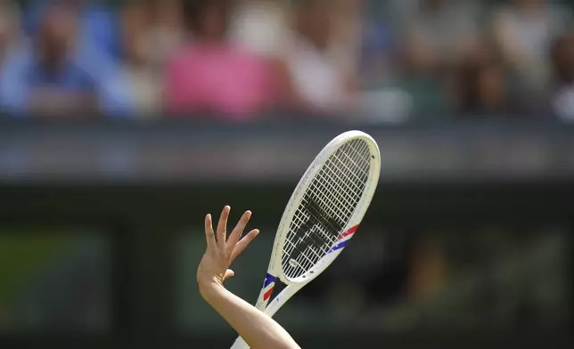 Iga Swiatek of Poland serves to Caty McNally of the U.S. during their second round women's singles match at the Wimbledon Tennis Championships in London, Thursday, July 3, 2025. (AP Photo/Alastair Grant)
