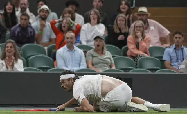 Taylor Fritz of the U.S. falls after he dived to return to Gabriel Diallo of Canada during their second round men's singles match at the Wimbledon Tennis Championships in London, Wednesday, July 2, 2025. (AP Photo/Alastair Grant)